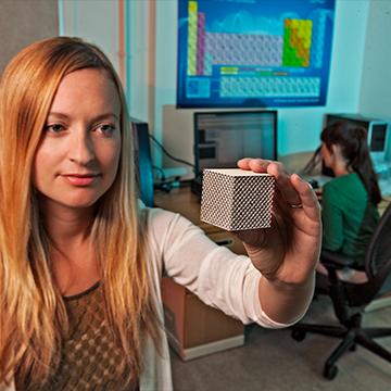 Employee examining 3D printed cube