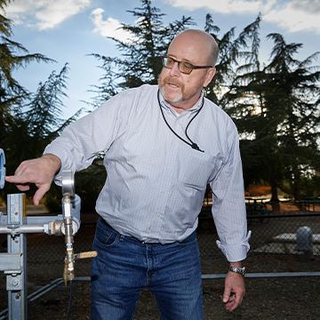 Man pointing at gages on water treatment equipment