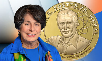 Miriam Johns in front of an image of the John S. Foster, Jr. medal