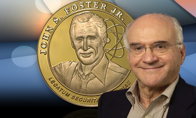 Victor Reis in front of an enlarged picture of the John S. Foster, Jr. medal